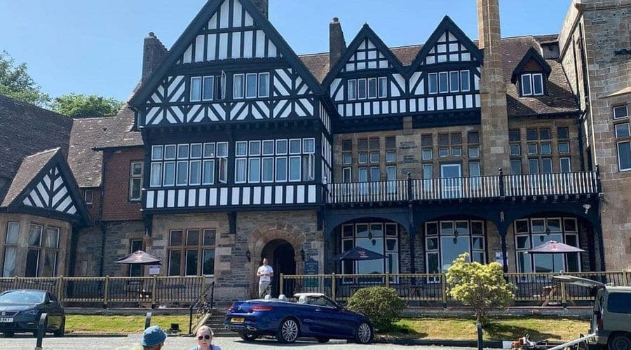 The Royal Marine Hotel in Dunoon, a black and white timber-framed building with parasols on the terrace