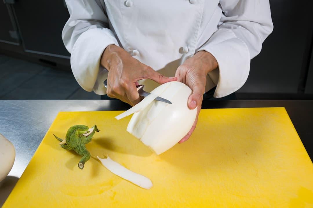 a person in a chef's coat is peeling an apple